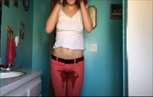 Sexy brunette takes a leak in her red pants